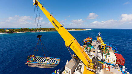 Pontoon being lifted onto cargo hold during the Aranui 5 South Sea cruise at Marquesas Island of Takapoto, French Polynesia